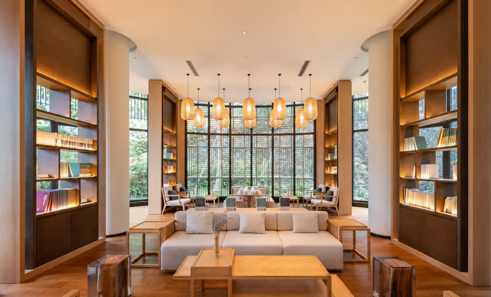 A quiet wood-lined library lounge with windows onto tropical greenery