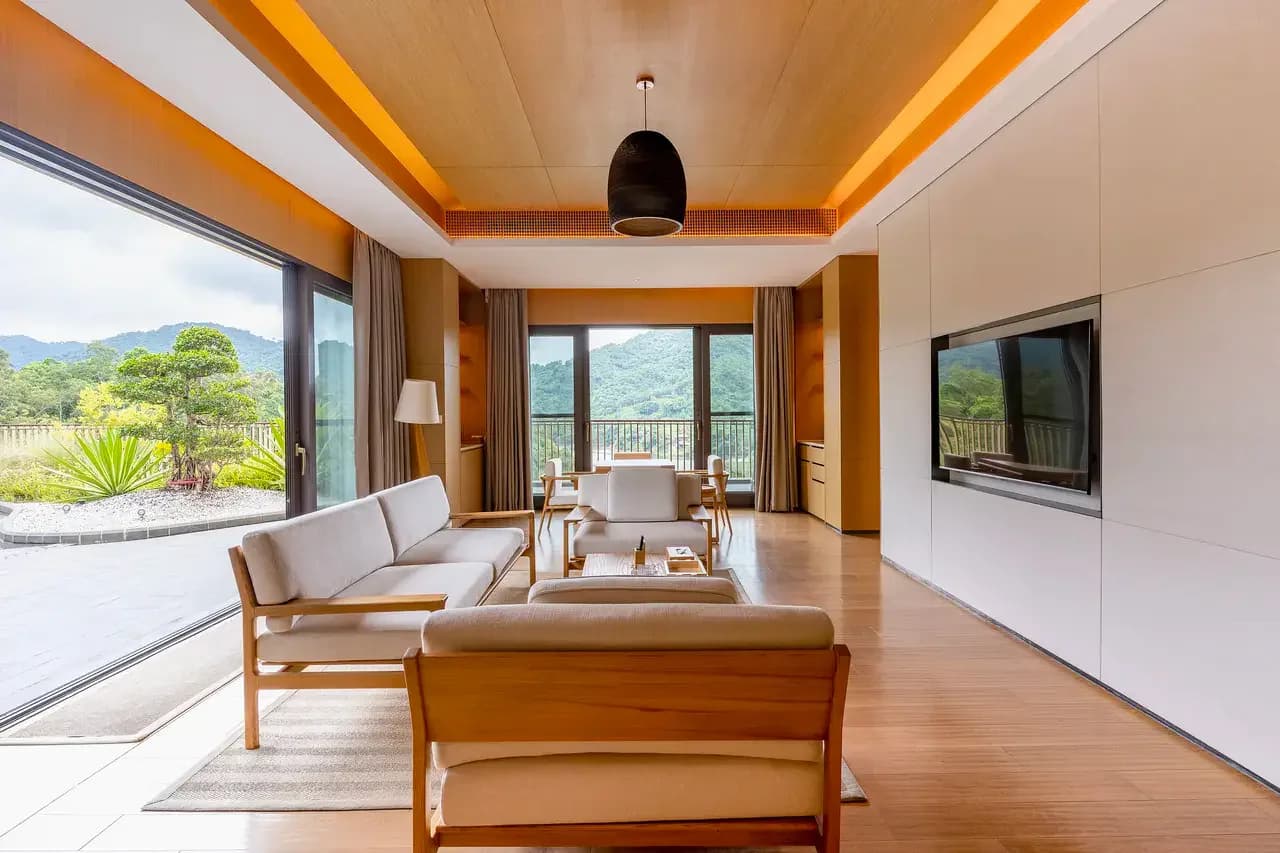 A quiet shared lounge opening toward mountain rainforest views