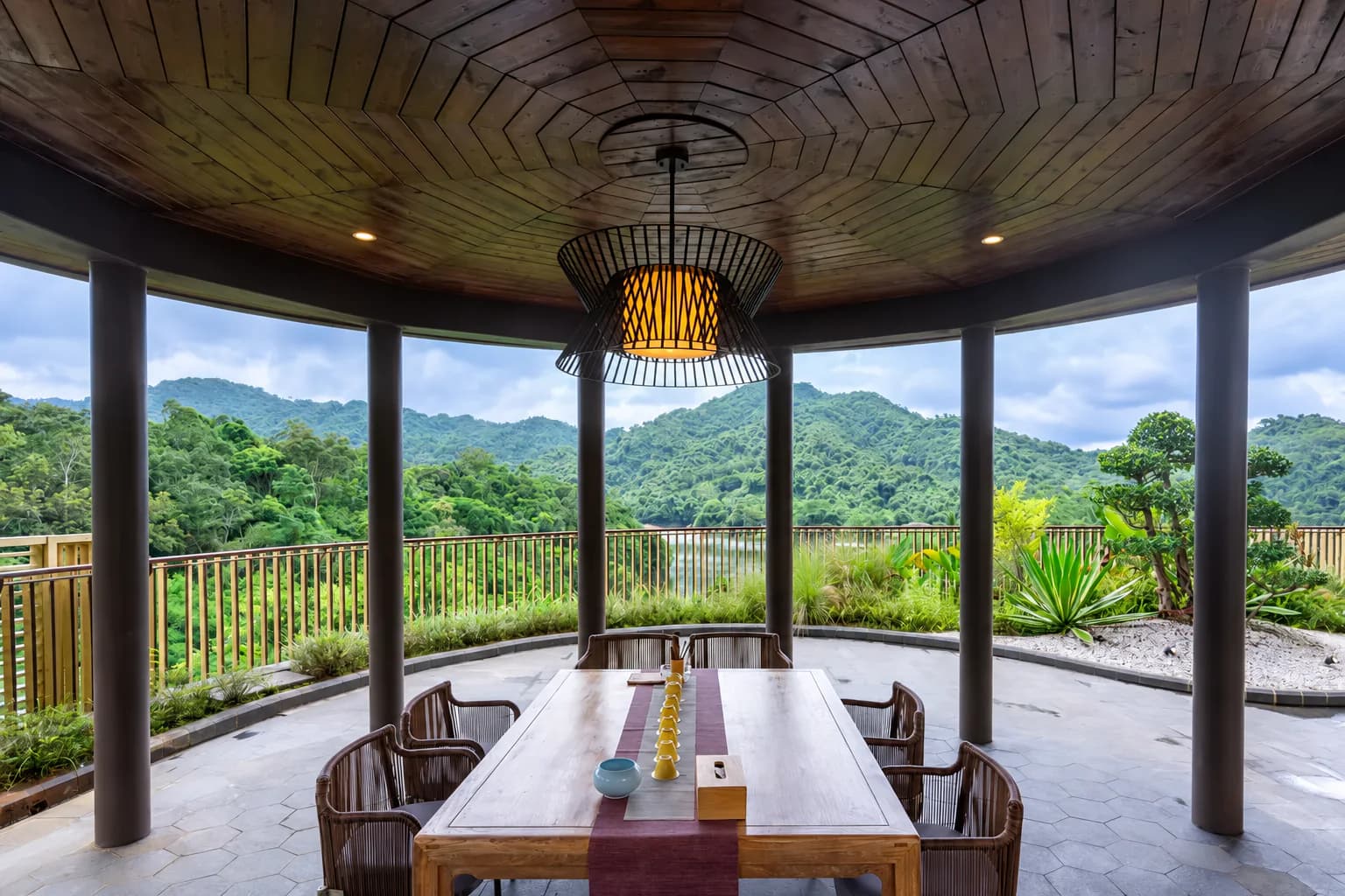 A long table in an open pavilion overlooking Hainan mountain rainforest