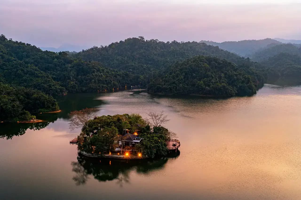 The small lake island at sunset, surrounded by Hainan mountain rainforest